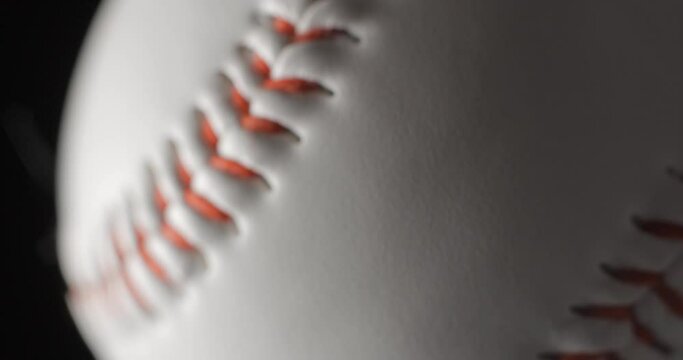 Baseball ball close up rotating in studio, vertical view