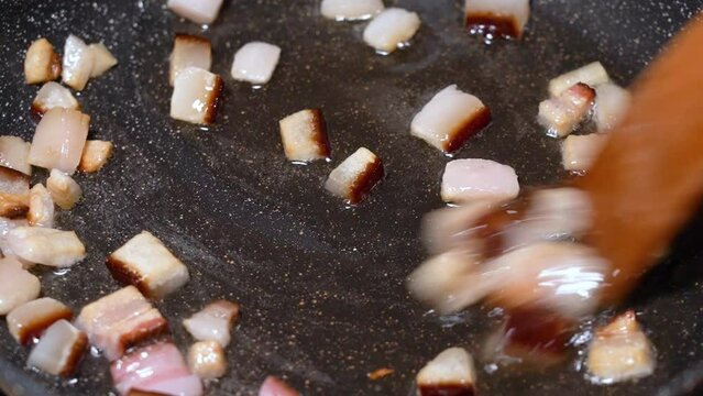 roasting of salted pork fatback on a red-hot pan, close-up