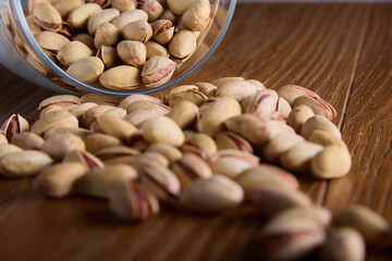 Beer hearty delicious snack of salted pistachios. Close-up of nutritious pistachio nuts in hard...
