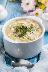 Tasty mushroom soup with noodles on a wooden table.