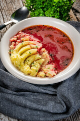 Red borscht soup in bowl.