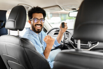 Fototapeta na wymiar Cheerful arab man holding key from auto, buying new car