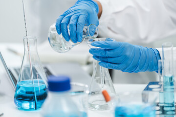 Young scientists conducting research investigations in a medical laboratory, a researcher in the foreground, Research and development concept with scientific and medical lab instrument, test tube