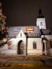 Fototapeta premium Low angle view of St. Mark's church in Zagreb, Croatia with Christmas tree at night