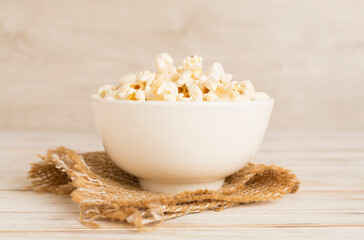 Popcorn in bowl on wooden table
