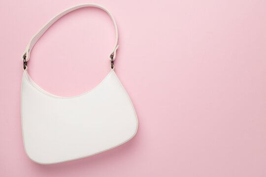 Trendy woman bag on color background, top view