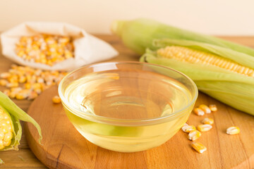 Corn oil with fresh cobs on wooden table