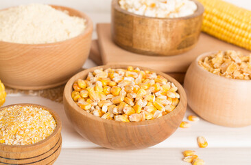 Maize products with fresh corn cobs on wooden table