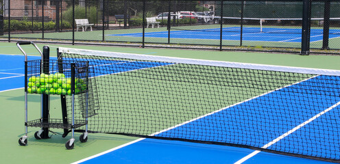 Bakset of tennis balls on a tennis court