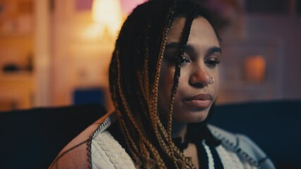 Young woman feeling sad while eating popcorn and watching TV, boring evening