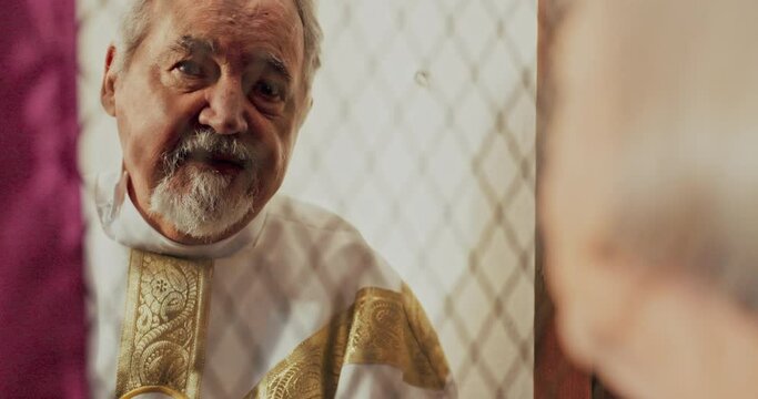 Priest, talking and listening in confession booth with senior woman, sinner or secret for forgiveness in church. Holy father, elderly lady and speaking for mental health, sorry or connection with God