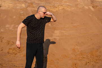 Short hair man on natural sand smelling something stinky and disgusting, intolerable smell, holding...