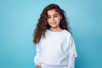 Fototapeta premium Girl with long curly hair wearing white sweatshirt mockup isolated on blue background. Generative AI.