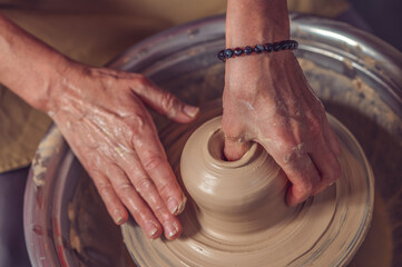 Ceramic bowl on a potter's wheel, ceramist's hands.