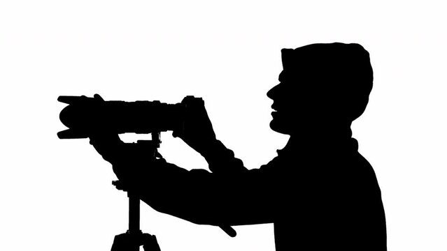Silhouette of a male videographer with a camera. black and white mask