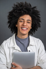 Young curly-haired digital nomad with a laptop in hands smiling