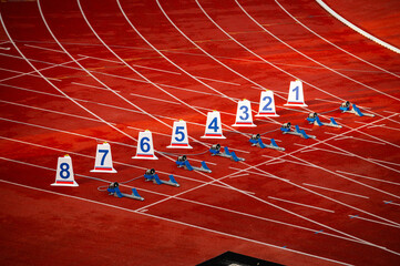 Start of sprint race. Numbers and starting blocks on the red track. Athletics stadium. Track and...