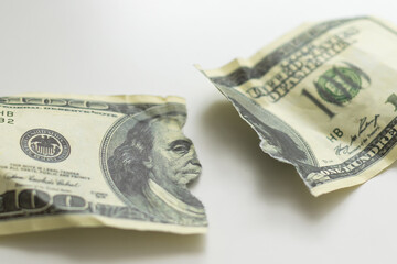a hundred dollar bill torn in half on a white background top view - obrazy, fototapety, plakaty