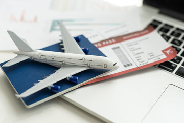 Air tickets, passports, money and toy plane on table