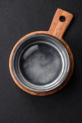 Empty round ceramic bowl on a wooden cutting board in brown color