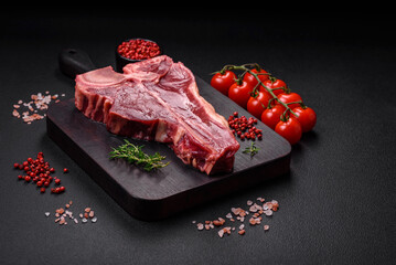 Raw fresh juicy beef t-bone steak with salt, spices and herbs