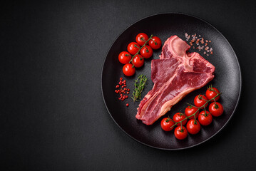 Raw fresh juicy beef t-bone steak with salt, spices and herbs