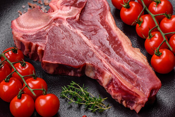 Raw fresh juicy beef t-bone steak with salt, spices and herbs