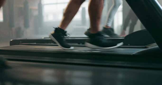 Feet, exercise and running shoes on a treadmill at gym for training and wellness of people. Closeup legs of athlete group together for cardio workout on machine for health, speed and fitness