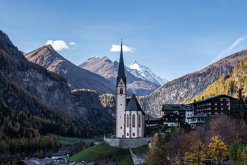 Kirche mit spitzem Turm mit Bergkulisse