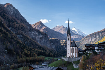 Kirche mit spitzem Turm inmitten von Bergen