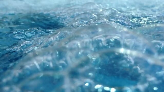 Video of pool water with cascading waterfall bubbles, a refreshing retreat
