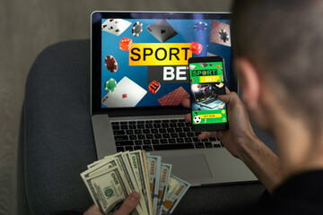 Man watching football play online broadcast on his laptop, cheering for his favourite team, making bets at bookmaker's website