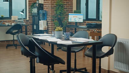 Coworking space with executive data on files, empty office desk filled with reports and analysis on papers. Corporate boardroom used for global business development, support strategy.