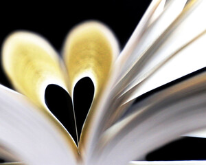open book flying open, heart-shaped pages 