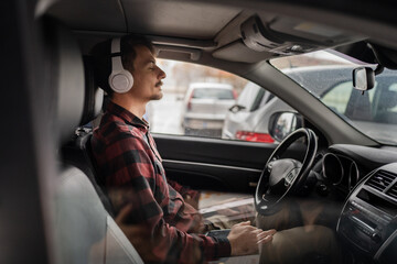 Fototapeta na wymiar one man with headphones sit in the car listen guided meditation