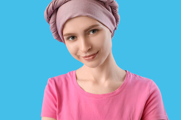 Teenage girl after chemotherapy on blue background, closeup