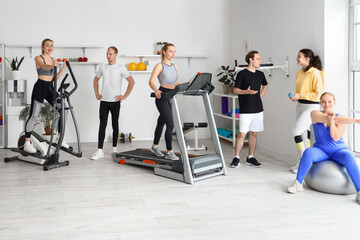 Group of sporty young people training in gym