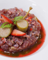 mediterranean food speciality, tuna tartare with strawberry in a white plate