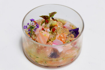 salmon ceviche in a glass dish with white background