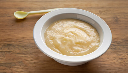 Bowl of healthy baby food on wooden table