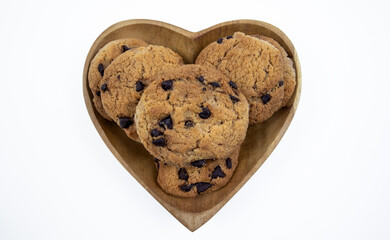 Chocolate chip cookies on a heart shaped plate on a white background