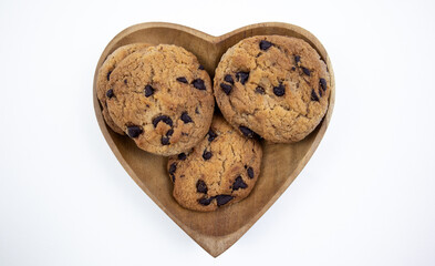 Chocolate chip cookies on a heart shaped plate on a white background