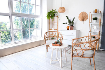 Interior of living room with armchairs, table and houseplants