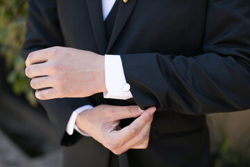 Obraz premium groom buttoning cufflinks