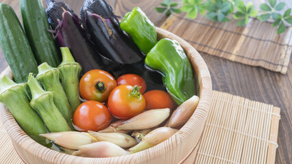 夏野菜イメージ・木桶に水を入れて野菜をつける｜きゅうり・なす・ピーマン・ミニトマト・オクラ・ミョウガ