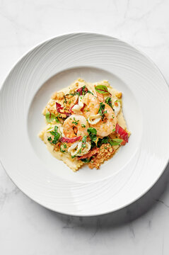 Raviolii pasta with prawns, shaved squid, garlic rainbow chard, verjuice beurre blanc & lemon pangrattato