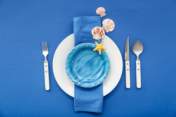 Beautiful table serving with marine decor on blue background