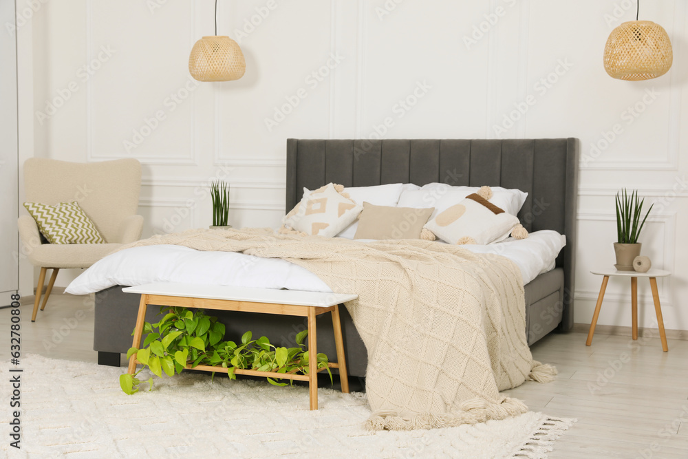 Sticker Stylish bedroom interior with large comfortable bed and armchair