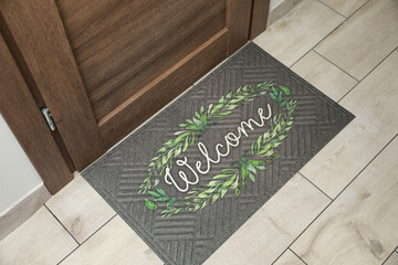 Beautiful doormat with word Welcome on floor near entrance, above view