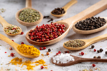 Various spices and seasonings in wooden spoons.